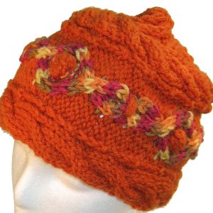 Orange hand knit hat with multi-color cable